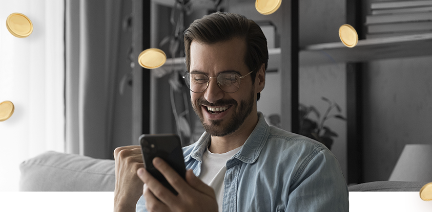 Imagem mostra homem sorrindo ao utilizar um smartphone